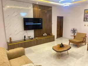 AbeokutaVilla Sofia的客厅配有沙发和墙上的电视