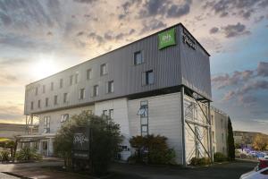 贝格莱ibis Styles Bordeaux Begles的一座白色的大建筑,上面有标志