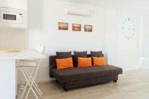 圣巴托洛梅Newly refurbished beachfront apartment.的客厅里配有带橙色枕头的沙发