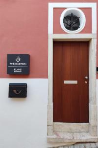 埃尔瓦斯The Bastion Elvas Apartments的一座建筑,上面有棕色的门和标志