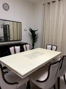 而连突Azlina Homestay Jerantut的一间会议室,配有白色的桌子和椅子