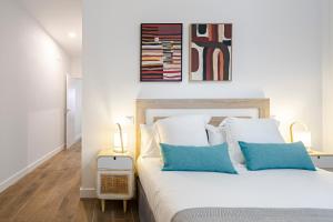 马德里Feelathome Castilla Apartments的一间卧室配有白色床和蓝色枕头