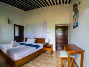 NgamboAurelia Zanzibar的一间卧室配有一张床、一张桌子和一张书桌
