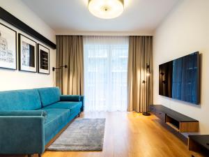 弗罗茨瓦夫City Comfort Wrocław的客厅配有蓝色的沙发和电视