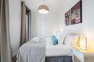 马德里Feelathome Castilla Apartments的一间卧室配有带白色床单和蓝色枕头的床。