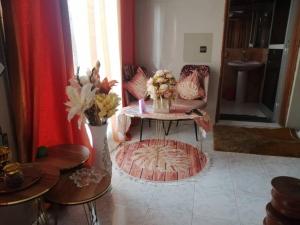 达喀尔Bienvenue CHEZ VOUS的客厅配有桌子和花瓶