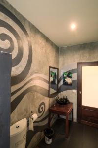 夜功府River CoCo @ Amphawa的一间带卫生间和壁画的浴室