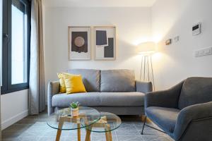 马德里Feelathome Castilla Apartments的带沙发和玻璃桌的客厅