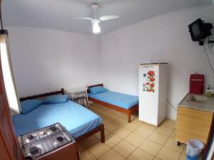 特拉曼达伊Pousada Tuiuti的小房间设有两张床和一台冰箱