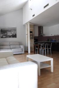 乌贝达Vivienda Turística Yamaries的客厅配有白色的沙发和桌子