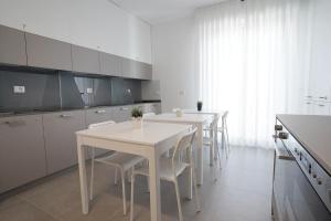 佩斯卡拉Piano Alto Home的白色的厨房配有白色的桌椅
