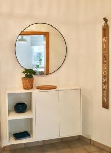 埃森BOHO APARTMENT: NETFLIX + BALCONY + BATHTUB的白色橱柜上方墙上的镜子