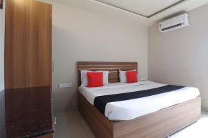 浦那Hotel Gaurav Residency的一间卧室配有一张带红色枕头的大床