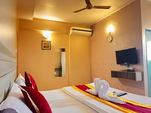 浦那Hotel Gaurav Residency的配有一张床和一台平面电视的酒店客房