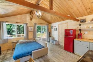 阿什福德Cozy Cedar Cabin Steps Away From Mt. Rainier的一间卧室配有一张床和一台红色冰箱