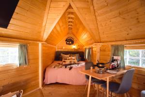 Le Kota B&B 4****的小木屋内的卧室,配有一张床和一张桌子