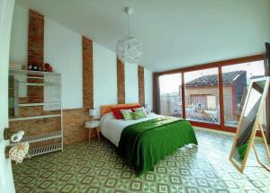 VimbodíCal Passió的一间卧室设有一张床和一个大窗户