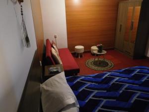 库斯科MALA HIERBA的一间卧室配有一张床、一张沙发和一张桌子