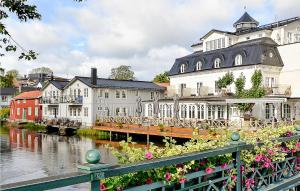 诺尔泰利耶Nice Home In Norrtlje With Wifi的一群花似的建筑物,毗邻一条河