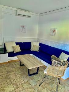 莫罗德哈布雷阿尔贝托SL公寓式酒店的一张蓝色的沙发,位于带桌椅的房间