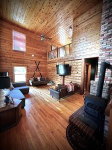BartonCabin close to Lake Willoughby and ski areas的大型客厅设有木墙和电视