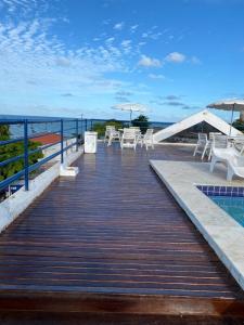 若昂佩索阿Quarto 215 do Manos Royal Hotel - propriedade privada的木板人行道,配有桌椅和游泳池