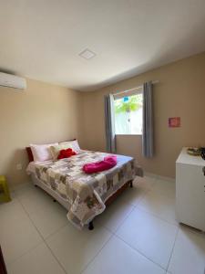 凯鲁Cond Praia Linda - Gamboa do Morro de São Paulo的一间卧室配有一张带粉色床单的床和一扇窗户。