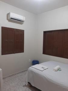 马卡帕L & C - Casa por Temporada的卧室配有一张床,墙上配有空调