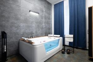 托伦Szampan i Truskawka的浴室设有浴缸,配有蓝色窗帘