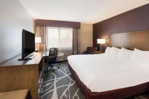 麦克明维尔Best Western McMinnville Inn的酒店客房设有一张大床和一台电视。