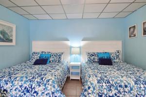 阿兰瑟斯港On the Half Shell - Condo的蓝色墙壁客房的两张床