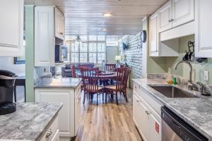 阿兰瑟斯港Pearl- Marlin的厨房配有白色橱柜和桌椅