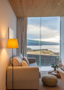 圣维森特费雷拉Sao Vicente Lodge - Atlantic Retreat的带沙发和大窗户的客厅