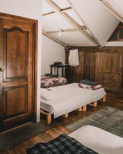 昆卡Wild Incas Hostel的一间设有两张床和木门的房间