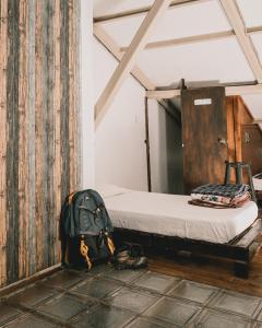 昆卡Wild Incas Hostel的背包坐在床边的地板上