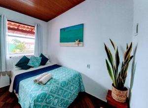 阿布拉奥Suites Casa Azul-Vila do Abraão- conforto, limpeza, ótima localização的一间卧室配有一张床和盆栽植物