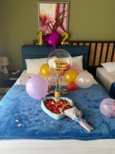 万津Relax At Gold Coast Morib的一张带气球的床和一盘食物