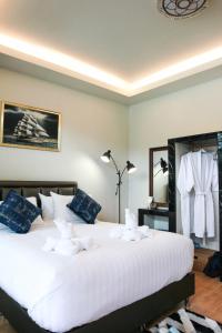 素叻Phetrapoolvilla (เภตราพูลวิลล่า)的卧室配有带蓝色枕头的大型白色床