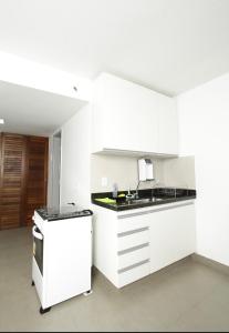戈亚尼亚Apartamento 1009的白色的厨房设有水槽和炉灶。