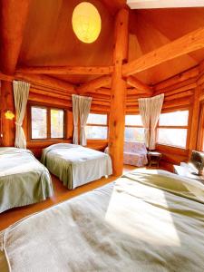 白马村Hakuba Pension & Log Hotel Meteor的小木屋内一间卧室,配有两张床