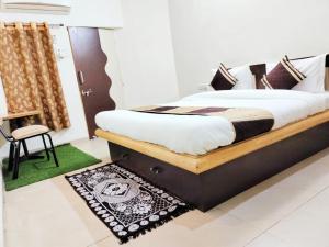 艾哈迈达巴德Homestayinn的一间卧室配有一张床、一把椅子和地毯