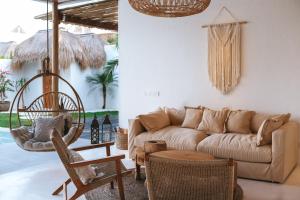 乌鲁瓦图Amaka Villas的客厅配有沙发和桌椅