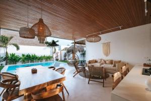 乌鲁瓦图Amaka Villas的一间带桌椅的客厅和一个游泳池