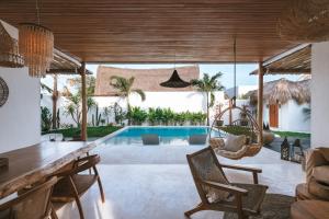 乌鲁瓦图Amaka Villas的开放式客厅、游泳池和别墅