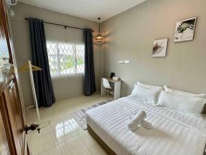 仙本那ANG LEE HOLIDAY HOME 2的卧室设有一张白色大床和一扇窗户。