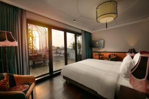 河内HOTEL du LAC Hanoi的一间卧室设有一张床和一个阳台的大窗户