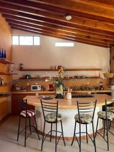 圣胡安德里奥Casa Ikal en San Juan del Rio con Alberca y Temazcal.的厨房配有桌椅和柜台。