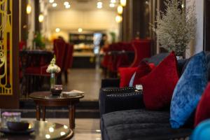 河内Flora Centre Hotel & Spa的客厅配有沙发和红色和蓝色枕头