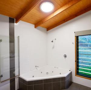 DayboroDayboro Cottages的大型浴室设有浴缸和淋浴。