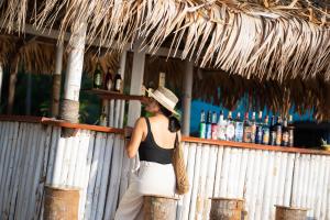 利邦岛利邦海滩度假酒店的站在酒吧后面的戴帽子的女人